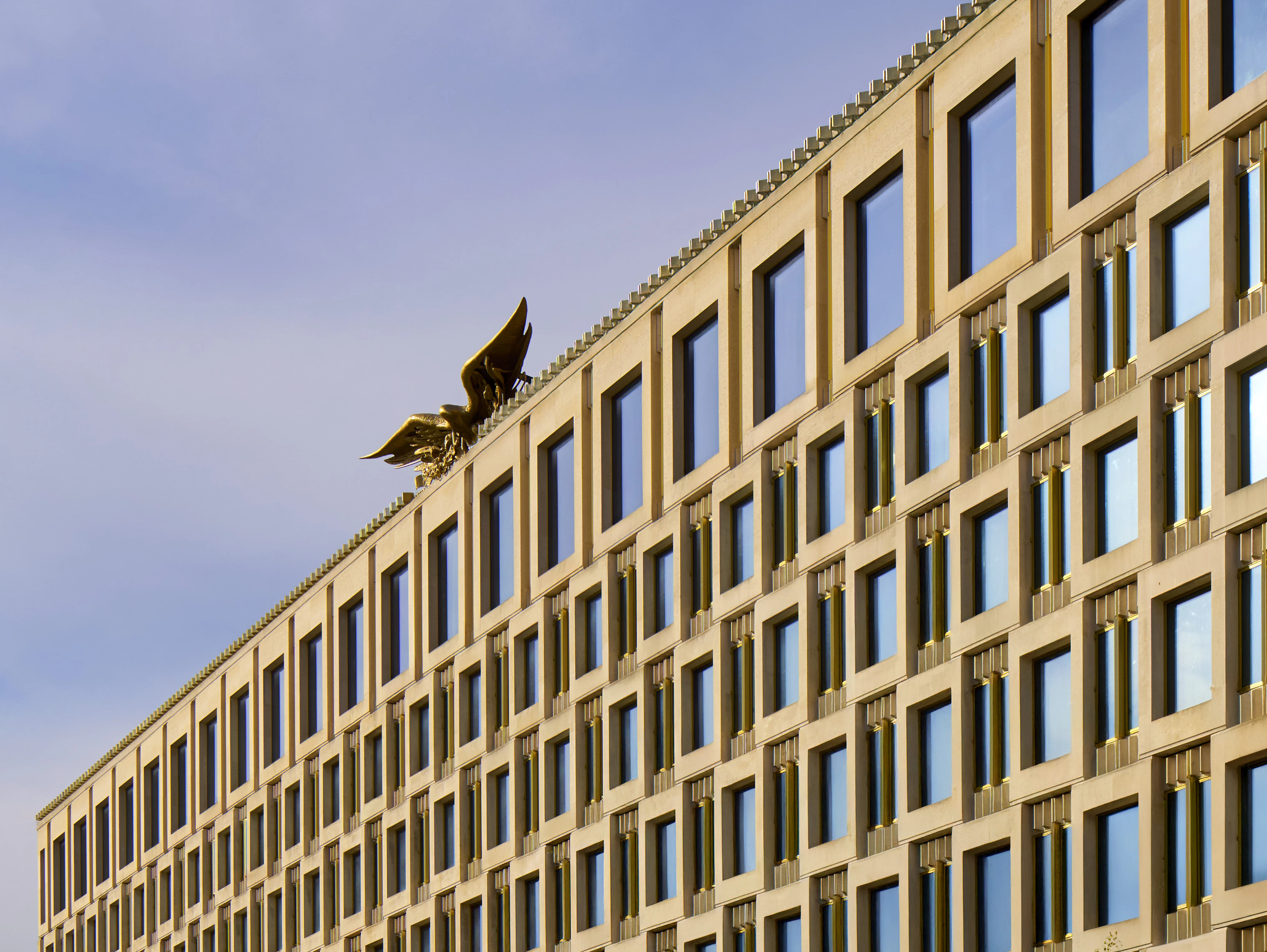 An exterior view of The Chancery Rosewood hotel in London, featuring the iconic golden eagle sculpture on the roof.